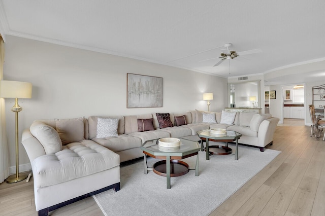 living room with crown molding, ceiling fan, and light hardwood / wood-style floors