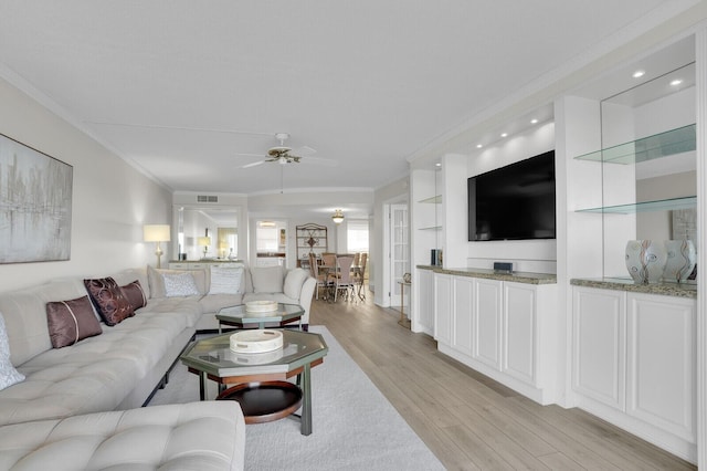 living room with ceiling fan, light wood-type flooring, and crown molding