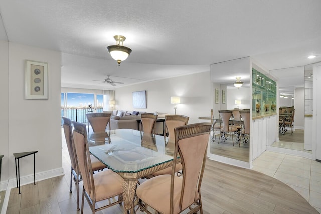 dining space with a textured ceiling, light hardwood / wood-style floors, and ceiling fan