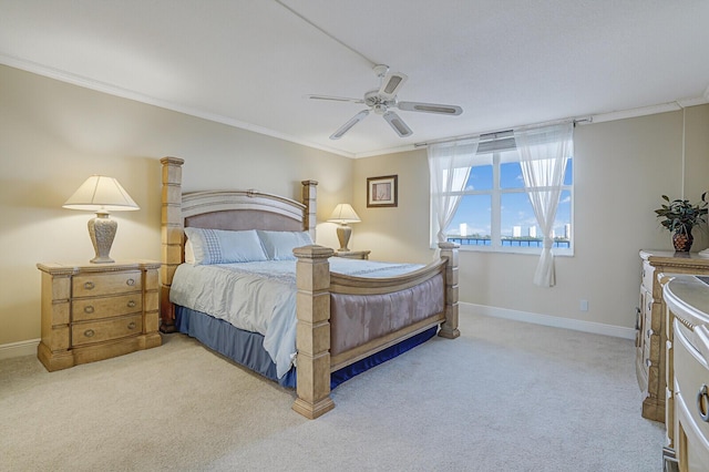 carpeted bedroom featuring ceiling fan and crown molding