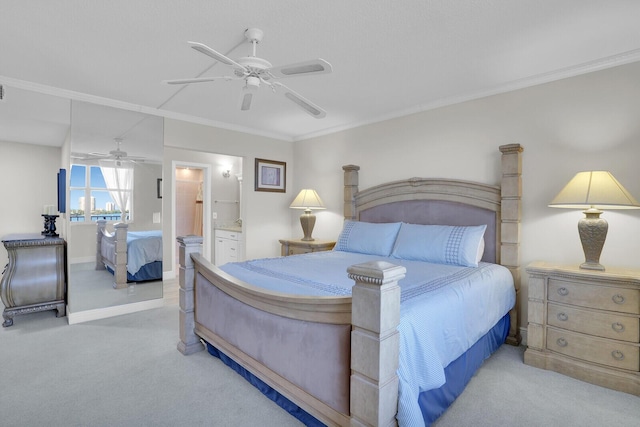 carpeted bedroom featuring ensuite bath, ceiling fan, and ornamental molding