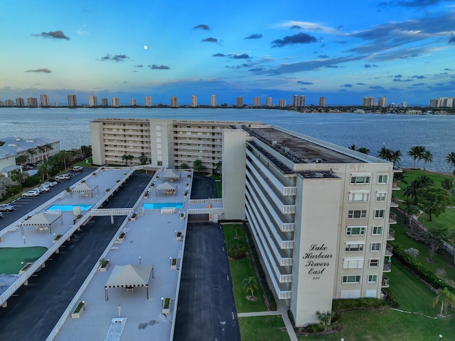 aerial view at dusk featuring a water view