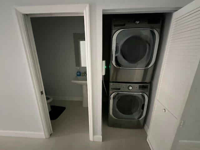 laundry area with tile patterned floors and stacked washer / dryer