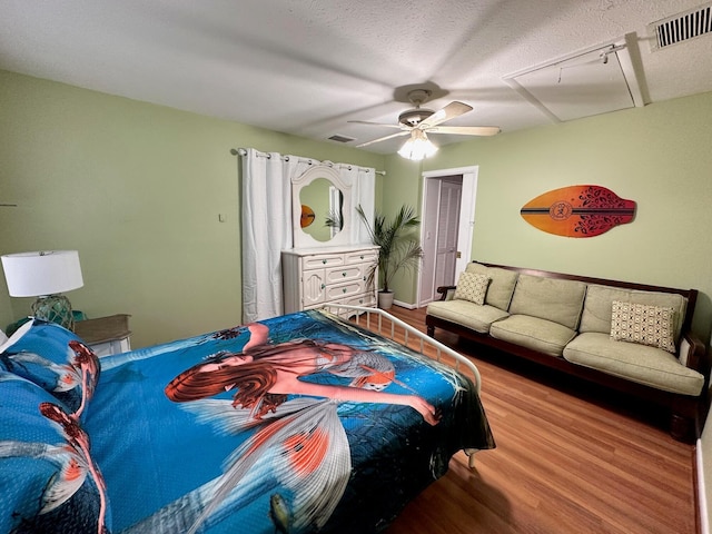 bedroom featuring hardwood / wood-style floors, a textured ceiling, and ceiling fan