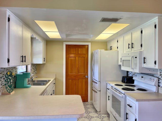 kitchen with kitchen peninsula, tasteful backsplash, white appliances, sink, and white cabinetry