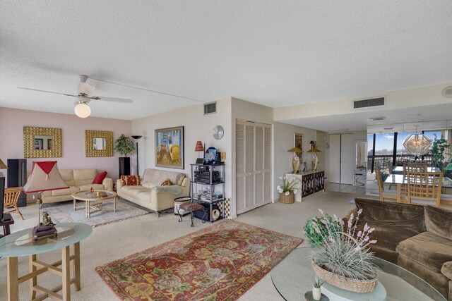 living room featuring light carpet, a textured ceiling, and ceiling fan