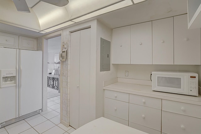 kitchen featuring light tile patterned floors, white appliances, and electric panel