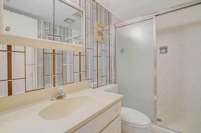 bathroom featuring vanity, toilet, and a shower with shower door