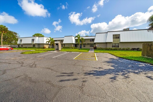 view of parking with a lawn