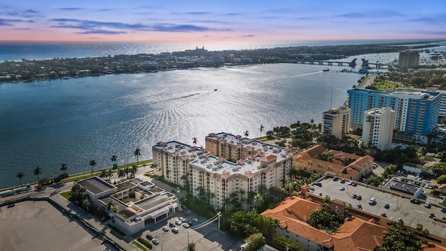 aerial view at dusk featuring a water view