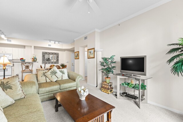 carpeted living room with ceiling fan, rail lighting, and ornamental molding