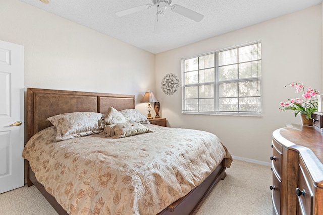 bedroom with light carpet, a textured ceiling, and ceiling fan