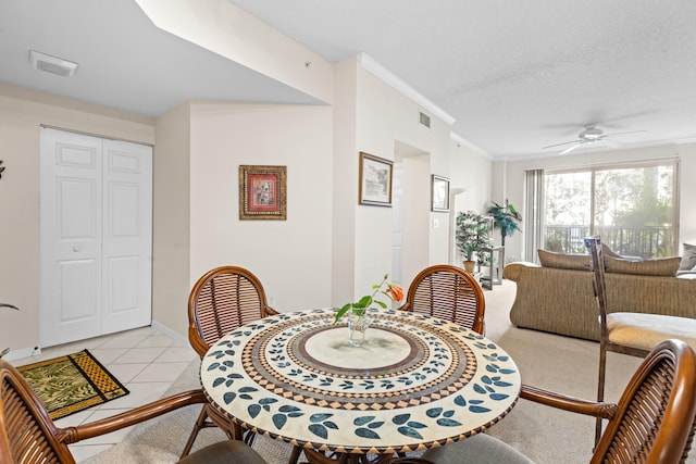 dining room featuring ceiling fan, crown molding, light tile patterned floors, and a textured ceiling