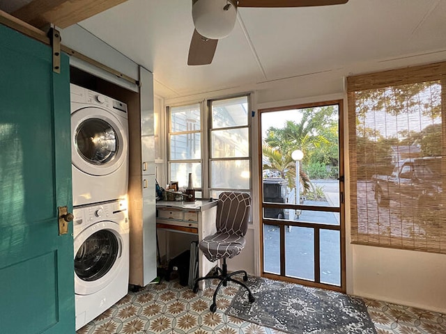 washroom with a barn door, ceiling fan, and stacked washer and dryer