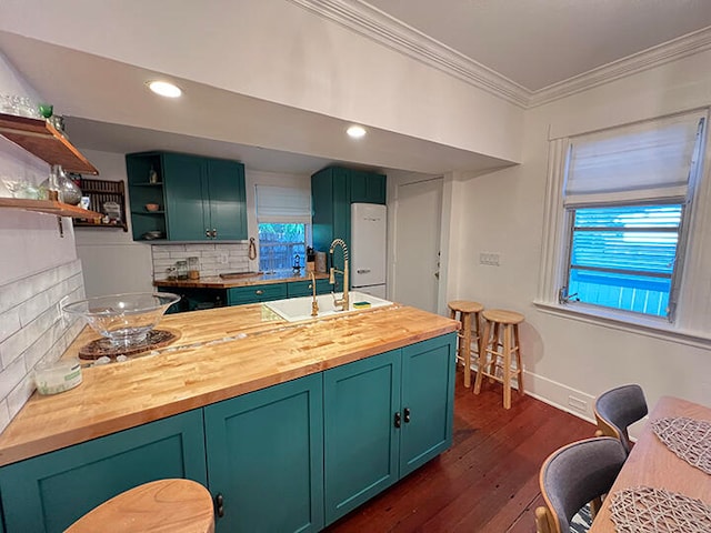 kitchen featuring dark hardwood / wood-style floors, butcher block countertops, backsplash, crown molding, and white fridge