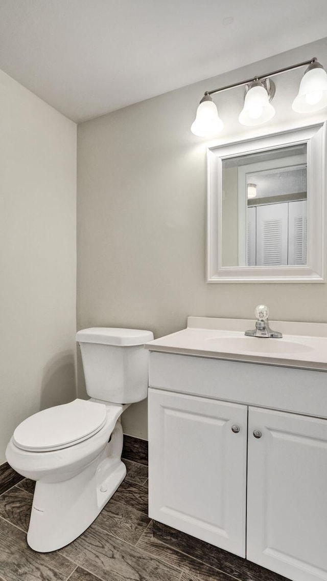 bathroom featuring vanity, wood-type flooring, and toilet