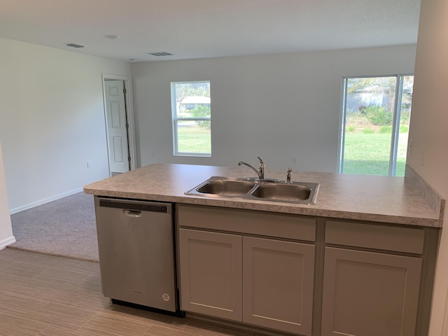 kitchen featuring gray cabinetry, sink, stainless steel dishwasher, a wealth of natural light, and light colored carpet