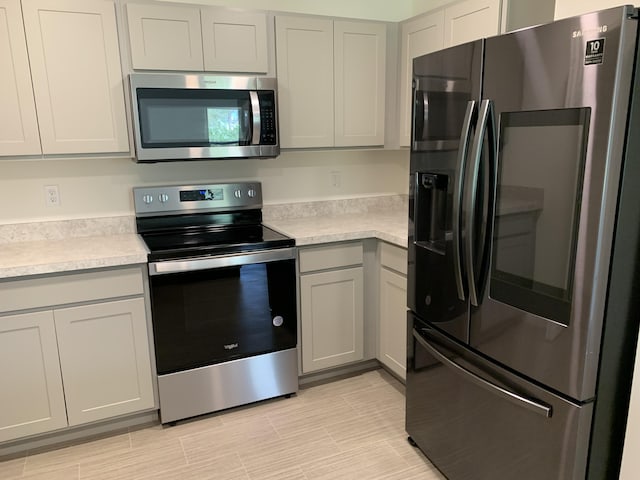 kitchen featuring sink, stainless steel appliances, gray cabinetry, and washing machine and clothes dryer