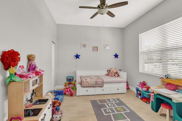 bedroom with light wood-type flooring, ceiling fan, and sink