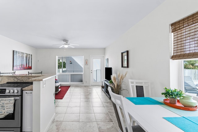 kitchen featuring electric stove, ceiling fan, and light tile patterned floors