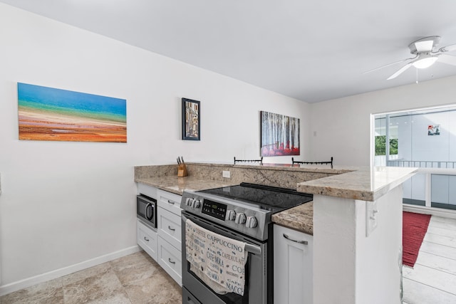 kitchen with kitchen peninsula, appliances with stainless steel finishes, white cabinetry, and light stone counters