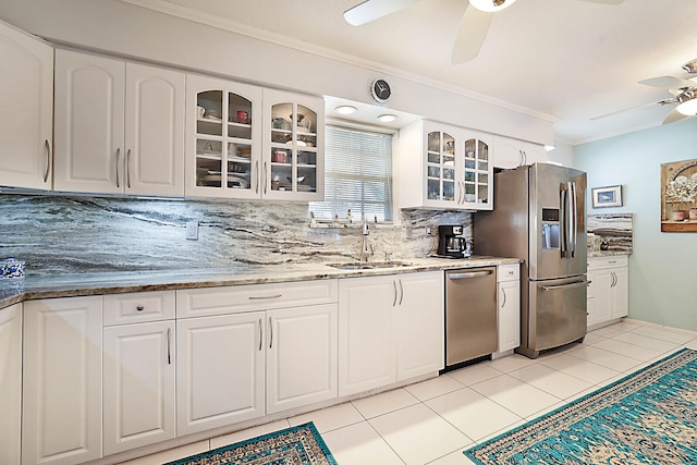 kitchen with backsplash, sink, white cabinets, and stainless steel appliances