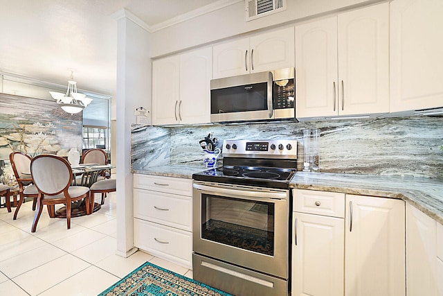 kitchen with backsplash, white cabinets, light tile patterned floors, and appliances with stainless steel finishes