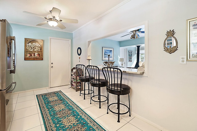 dining space featuring ceiling fan, light tile patterned floors, crown molding, and a wealth of natural light