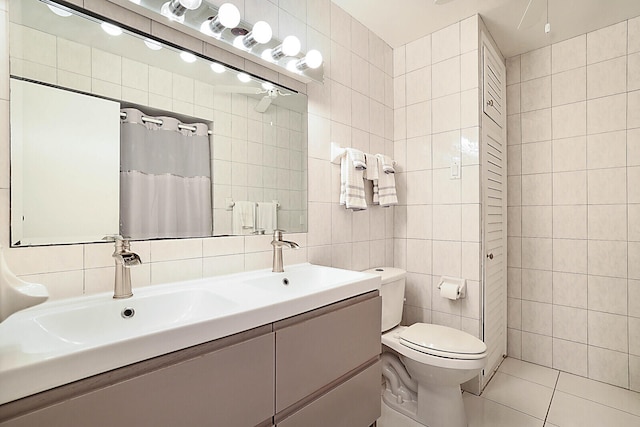 bathroom featuring tasteful backsplash, tile patterned floors, vanity, tile walls, and toilet