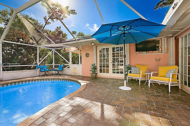 view of swimming pool featuring glass enclosure and a patio area