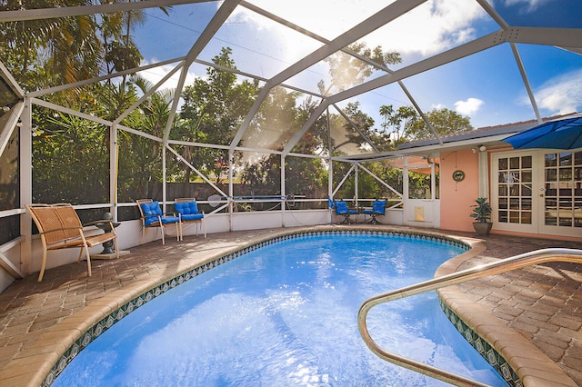 view of pool with a lanai, a patio area, and french doors