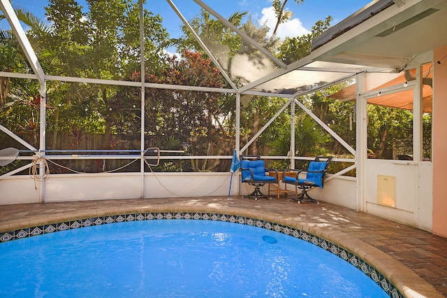 view of pool featuring glass enclosure and a patio area