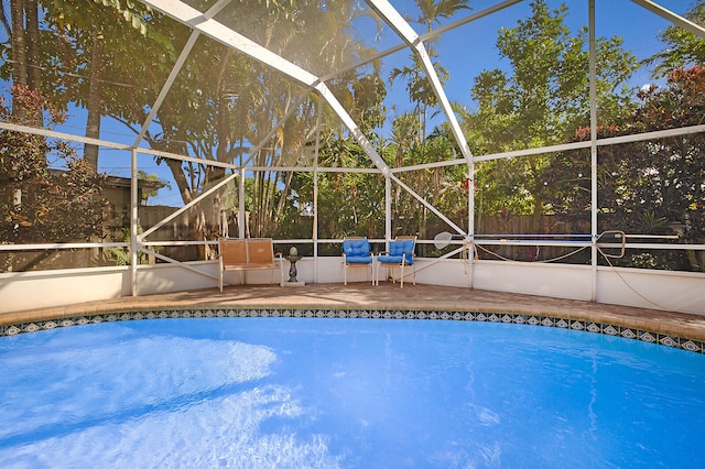 view of pool featuring glass enclosure and a patio area