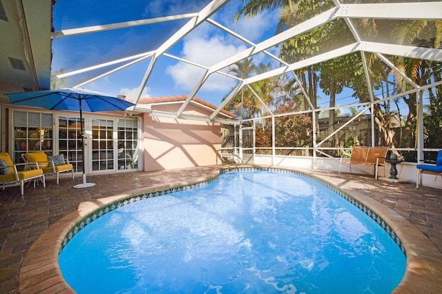 view of swimming pool featuring a lanai and a patio area