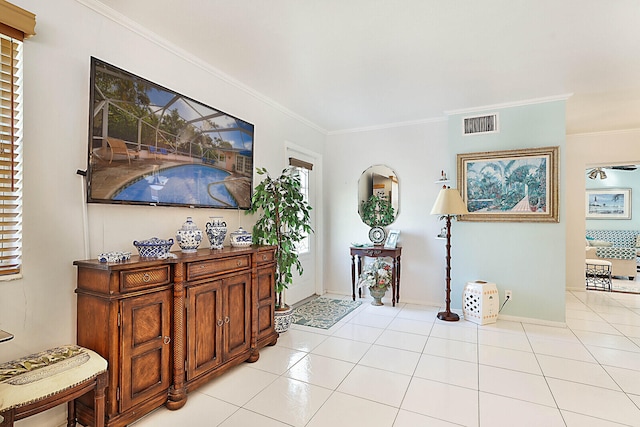 tiled foyer featuring ornamental molding