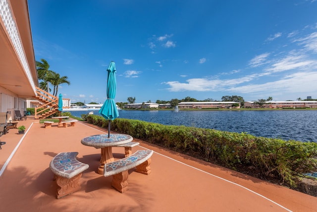 surrounding community featuring a water view and a patio area