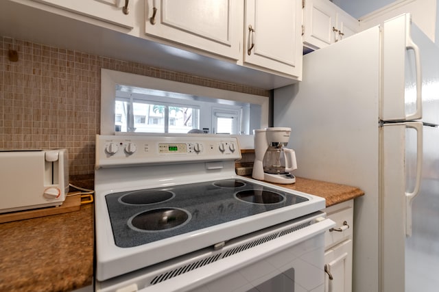 kitchen with white range with electric stovetop and white cabinets