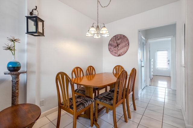 tiled dining room featuring an inviting chandelier