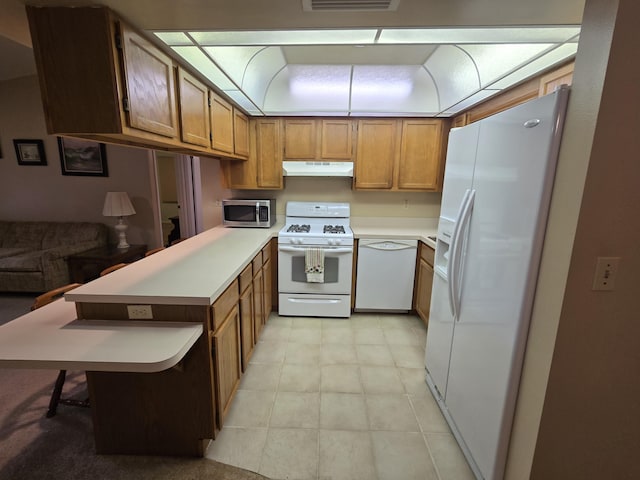 kitchen with white appliances, under cabinet range hood, light countertops, and brown cabinetry