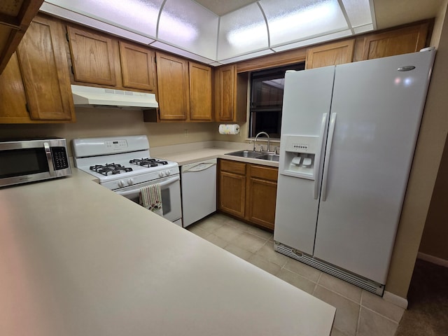 kitchen with sink, light tile patterned floors, and white appliances