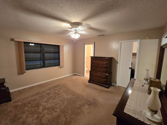 unfurnished bedroom featuring ceiling fan, a textured ceiling, connected bathroom, and light carpet