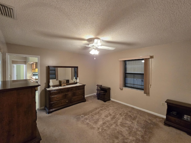 bedroom with visible vents, a ceiling fan, light carpet, a textured ceiling, and baseboards