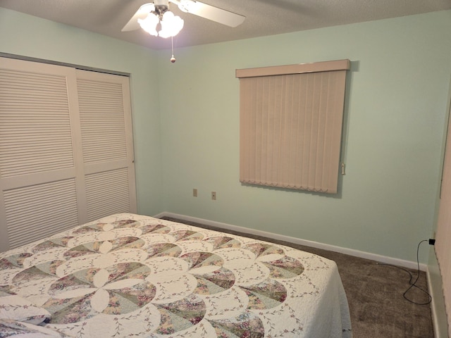 bedroom with a ceiling fan, dark colored carpet, a closet, and baseboards