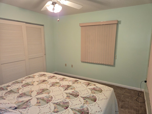 bedroom with ceiling fan, dark carpet, a textured ceiling, and a closet