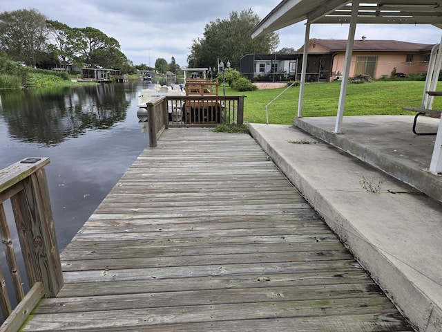 dock area featuring a water view and a yard