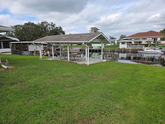 dock area with a water view and a lawn