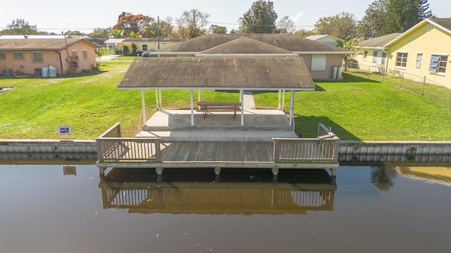 dock area with a gazebo, a patio, a lawn, and a water view