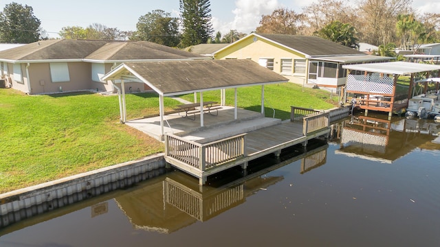 view of dock with a water view, a lawn, and a patio