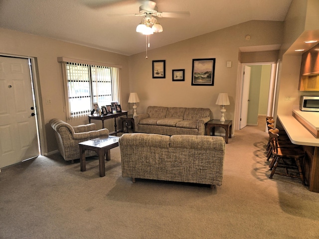 carpeted living room featuring ceiling fan and vaulted ceiling