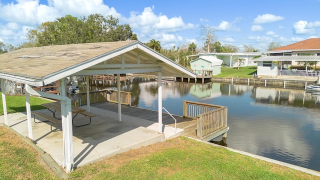 dock area with a water view and a lawn